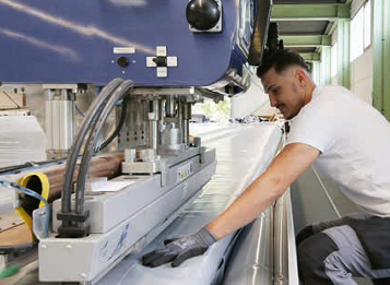 Mitarbeiter an einer industriellen Verarbeitungsmaschine für Textilmembranen